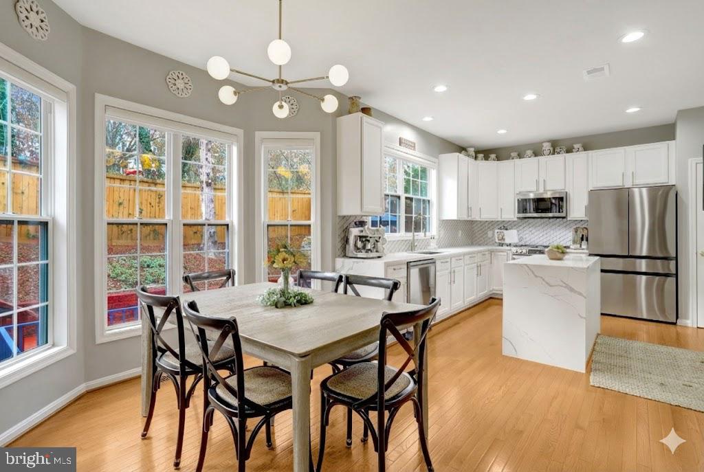 7374 Pohick Ridge Court Springfield, VA 22153 - Photo 8 of 58 a kitchen with refrigerator a sink and chairs