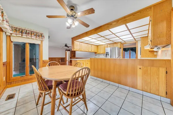 an empty room with wooden floor chandelier fan and windows