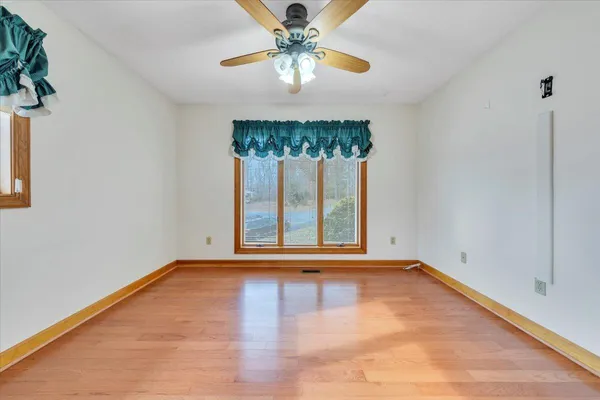 a view of an empty room with window and a bathroom