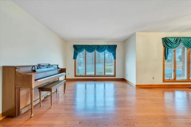 a kitchen with stainless steel appliances granite countertop a refrigerator a sink dishwasher and white cabinets next to a window