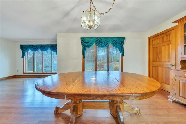 a kitchen with stainless steel appliances granite countertop a refrigerator a sink dishwasher and white cabinets next to a window