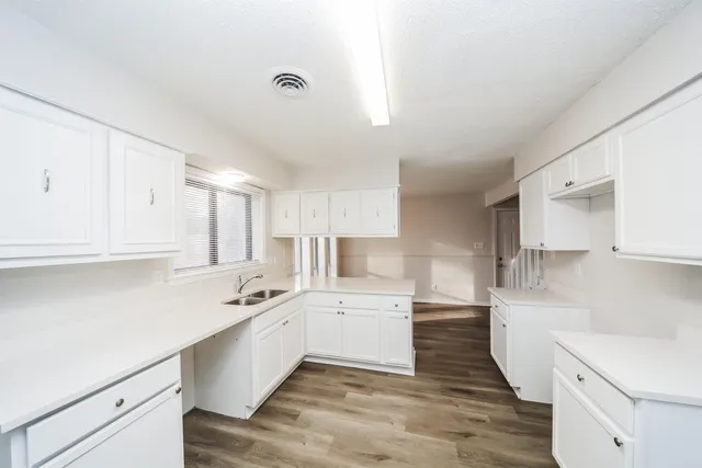 a kitchen with a sink a white cabinets and white appliances