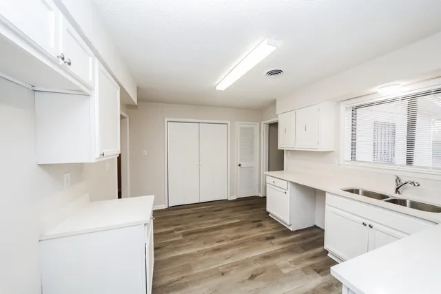 a kitchen with a refrigerator and white cabinets