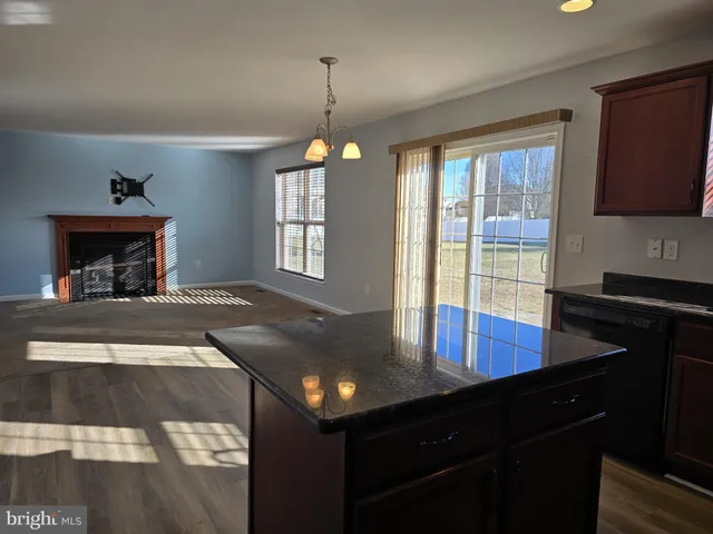 a view of a room with a chandelier and wooden floor