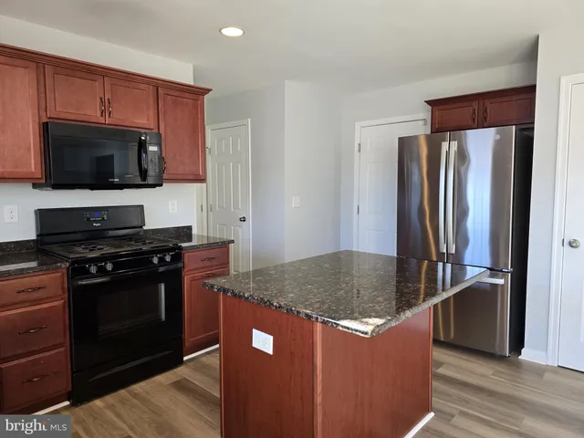 a kitchen with stainless steel appliances granite countertop a stove a refrigerator and a sink