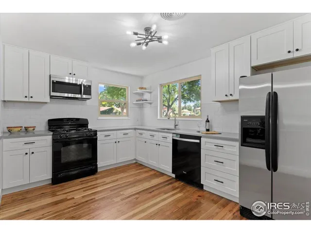 a kitchen with stainless steel appliances kitchen island granite countertop a refrigerator stove and sink