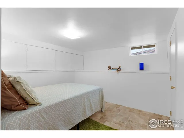 a bedroom with a bed and a white wall
