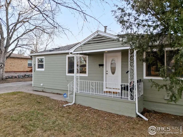 a view of a house with a yard and large tree