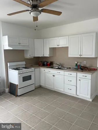 a kitchen with granite countertop a sink cabinets and stainless steel appliances