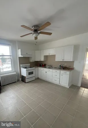 a kitchen with stainless steel appliances granite countertop a stove a sink and white cabinets