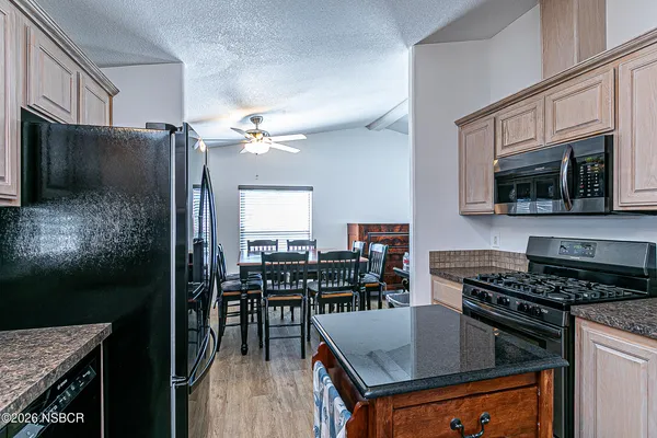 a kitchen with stainless steel appliances granite countertop a stove refrigerator sink and cabinets