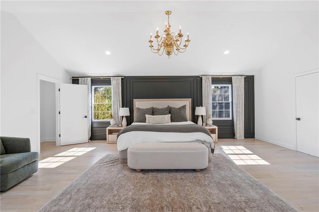 403 Rockbridge Road Southwest Lilburn, GA 30047 - Photo 34 of 77 a spacious bedroom with a bed and a chandelier