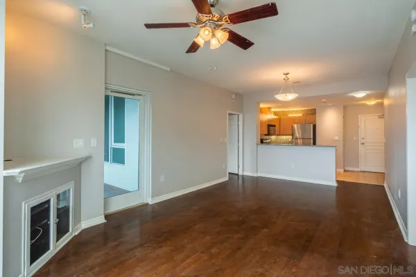 a view of a livingroom with a hardwood floor a ceiling fan and a window
