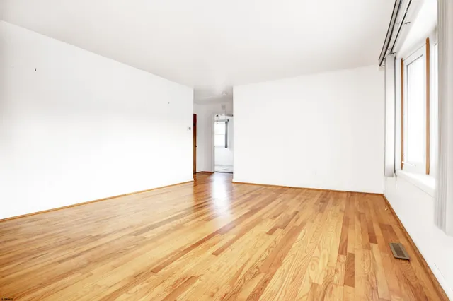 a view of a big room with wooden floor and brick walls