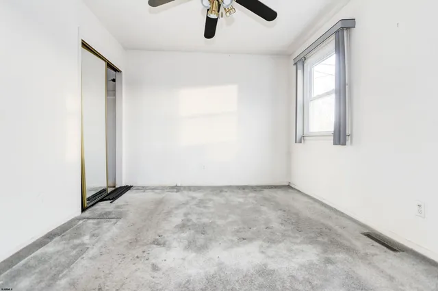 an empty room with windows and cabinet