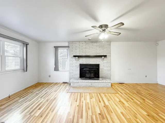 a view of empty room with a fireplace and fan