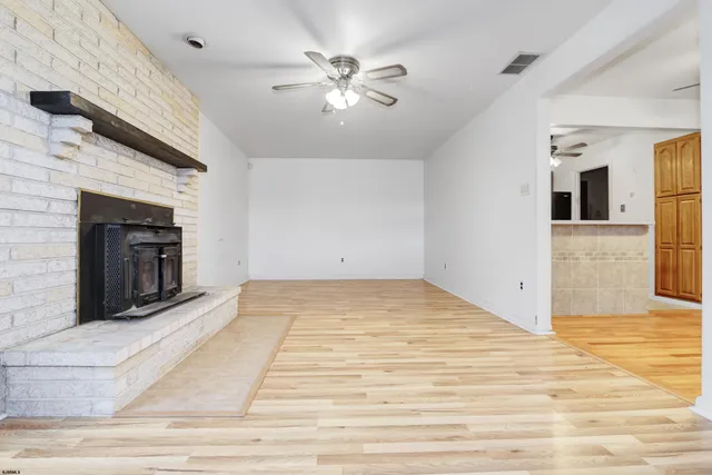a view of a livingroom with a fireplace and wooden floor