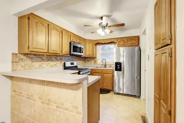 a kitchen with stainless steel appliances granite countertop a refrigerator a stove a sink and a microwave