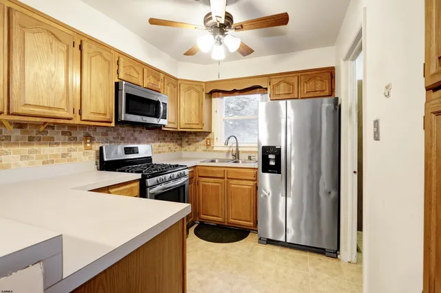 a kitchen with stainless steel appliances granite countertop a refrigerator a stove top oven a sink and dishwasher