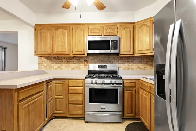 a kitchen with stainless steel appliances granite countertop a stove a sink and a refrigerator