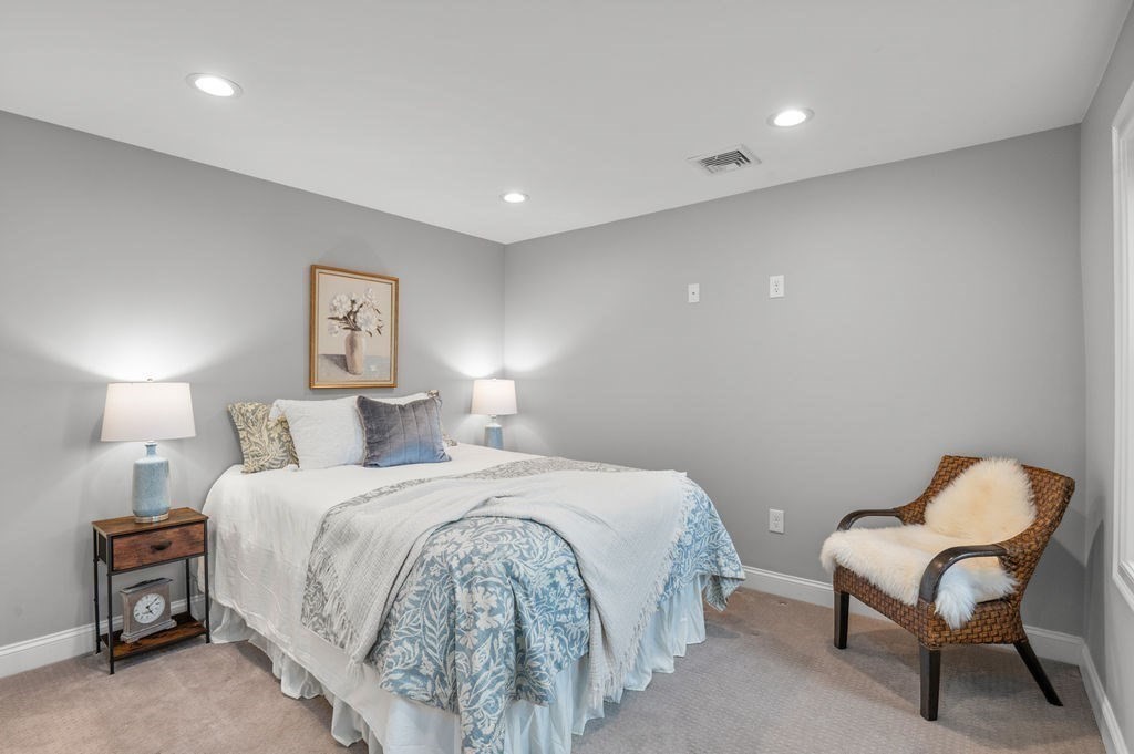 27 Warren Street, Unit 1 Newburyport, MA 01950 - Photo 20 of 32 a bedroom with a bed and a chair