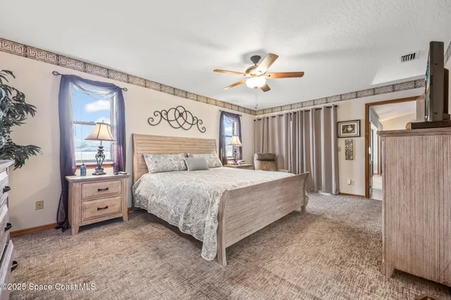 a spacious bedroom with a bed and a chandelier