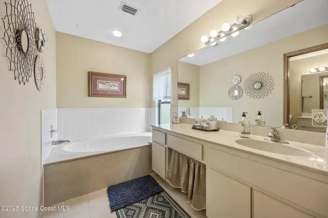 a bathroom with a double vanity sink a mirror and a bathtub