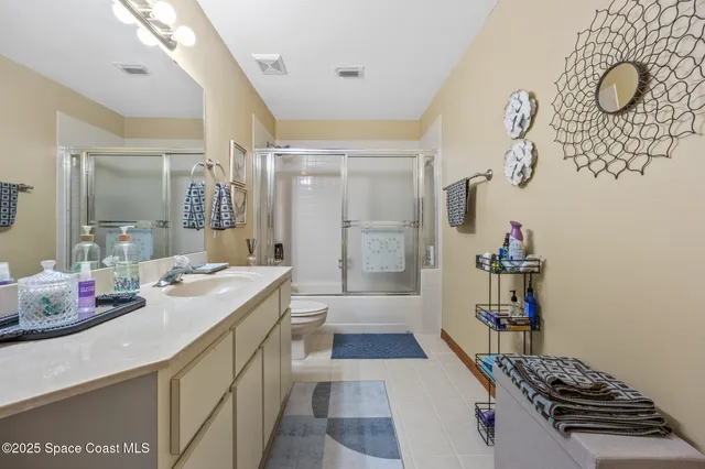 a bathroom with a granite countertop sink a toilet and shower