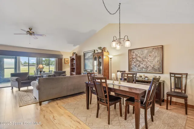 a dining room with furniture a chandelier and wooden floor