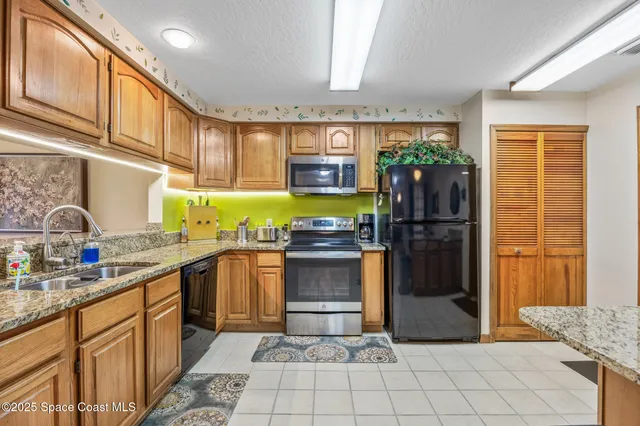 a kitchen with stainless steel appliances granite countertop a granite counter tops and a refrigerator