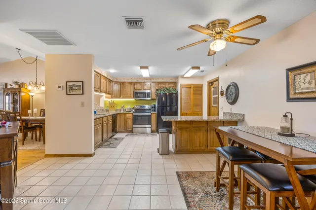 a living room with stainless steel appliances kitchen island granite countertop furniture and a dining table