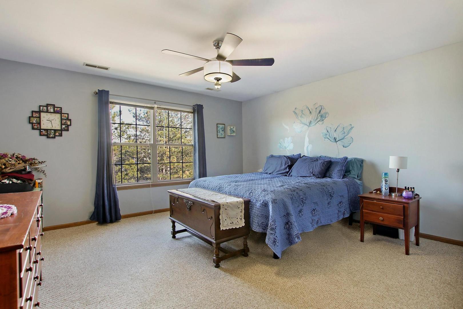 521 Willow Way Lindenhurst, IL 60046 - Photo 11 of 24 a spacious bedroom with a bed and a chandelier