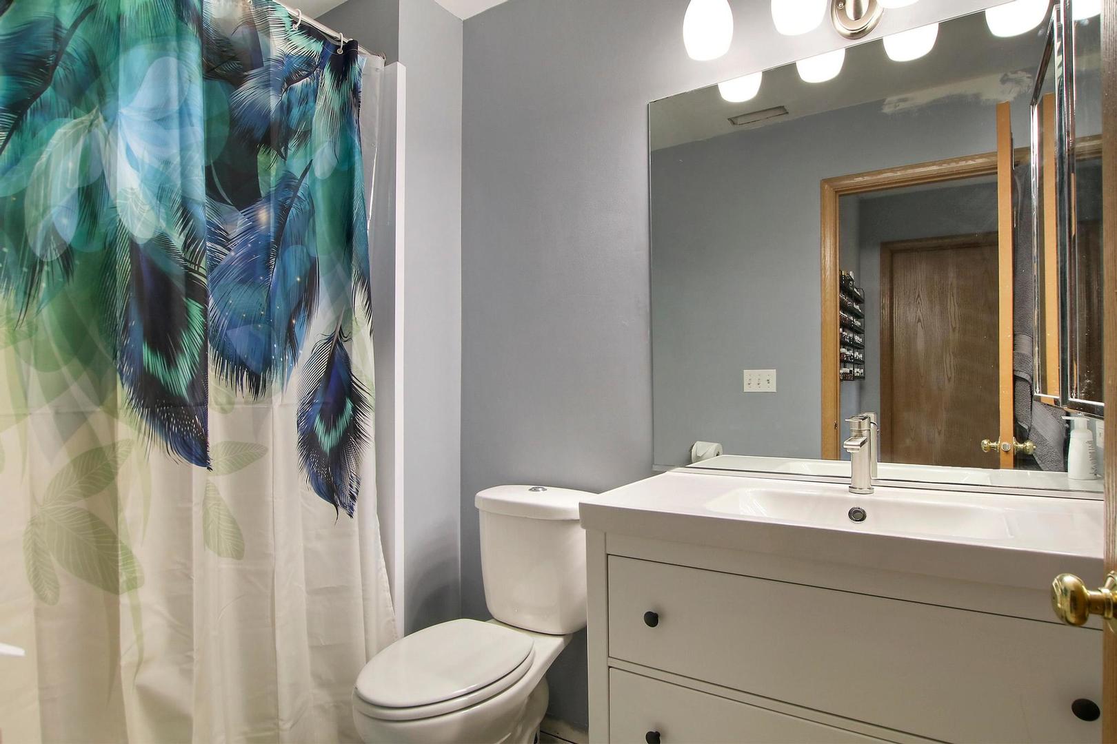 521 Willow Way Lindenhurst, IL 60046 - Photo 13 of 24 a bathroom with a sink vanity mirror and toilet