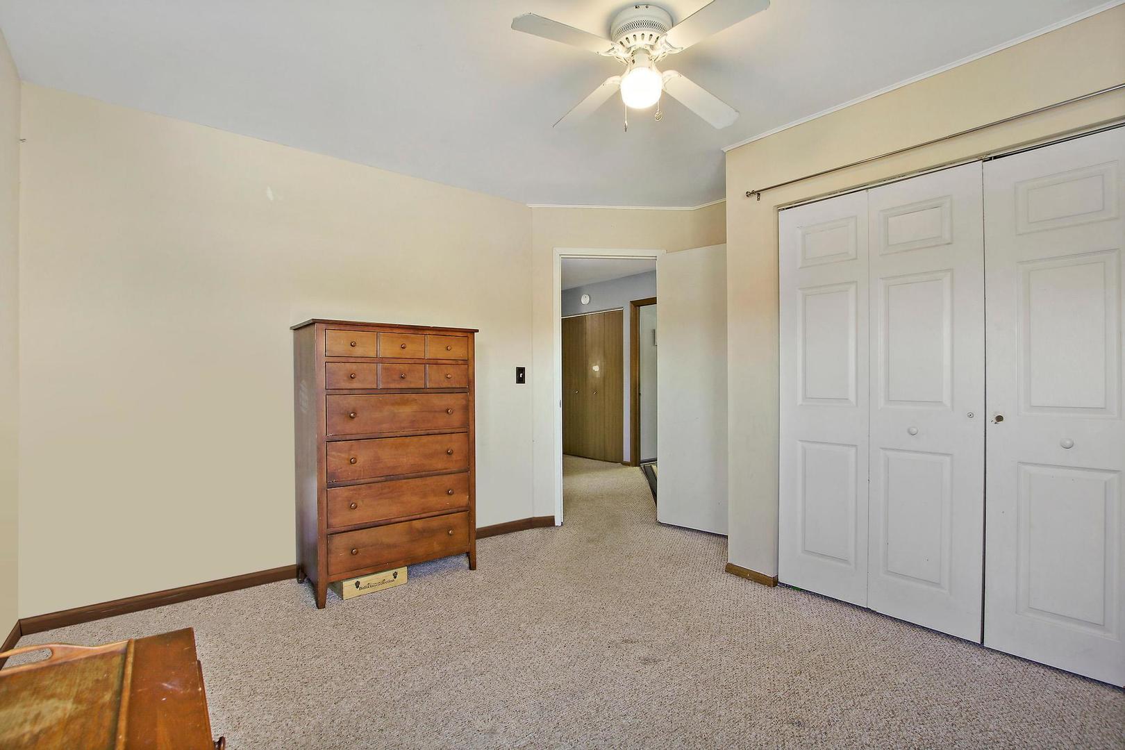 521 Willow Way Lindenhurst, IL 60046 - Photo 18 of 24 an empty room with closet and a chandelier fan