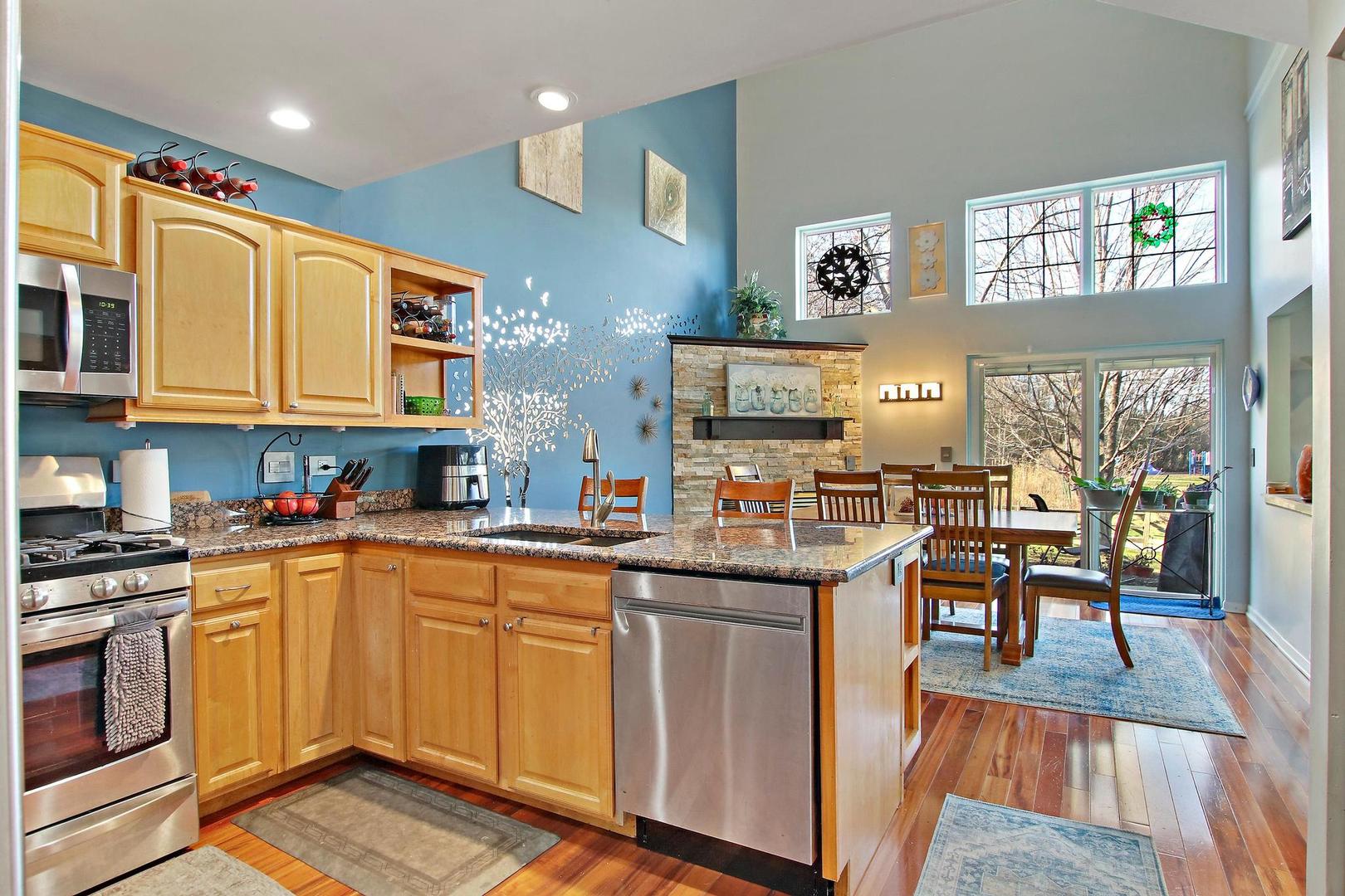 521 Willow Way Lindenhurst, IL 60046 - Photo 6 of 24 a kitchen with stainless steel appliances granite countertop a stove top oven a sink dishwasher and white cabinets with wooden floor