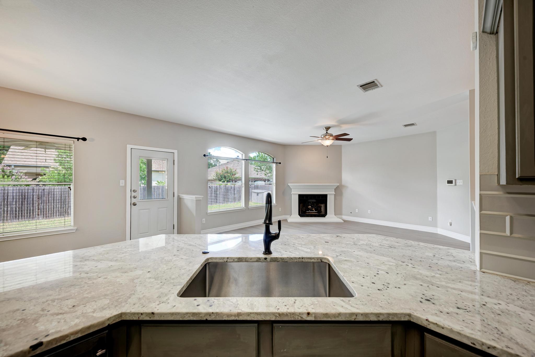 4408 Tello Path Austin, TX 78749 - Photo 38 of 38 Kitchen with a ceiling fan, open floor plan, light stone counters, and wood finished floors
