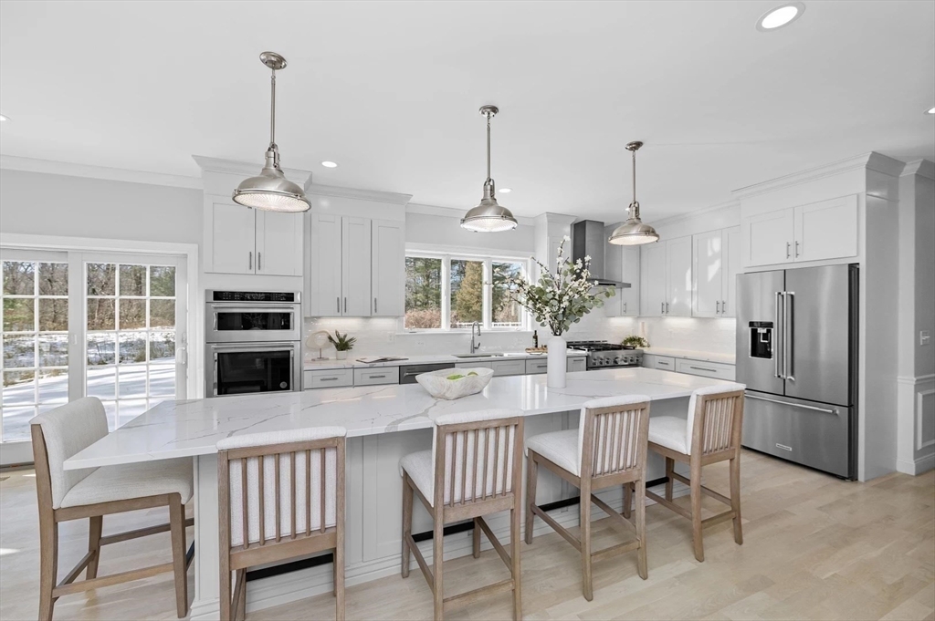 Lot 6 Osprey Court Rowley, MA 01969 - Photo 10 of 25 a kitchen with refrigerator cabinets dining table and chairs