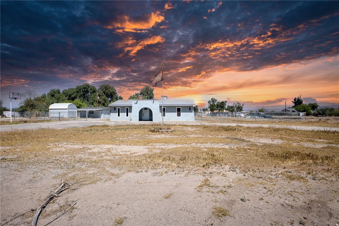 The property features a stucco exterior, an arched entryway, and a flagpole