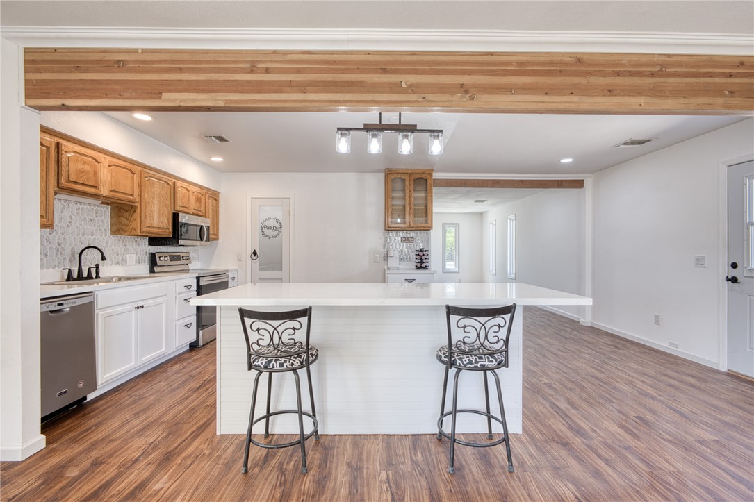 2053 Regents Road Mohave Valley, AZ 86440 - Photo 10 of 65 Well-appointed kitchen featuring a large island with seating, stainless steel appliances, and wood-look flooring