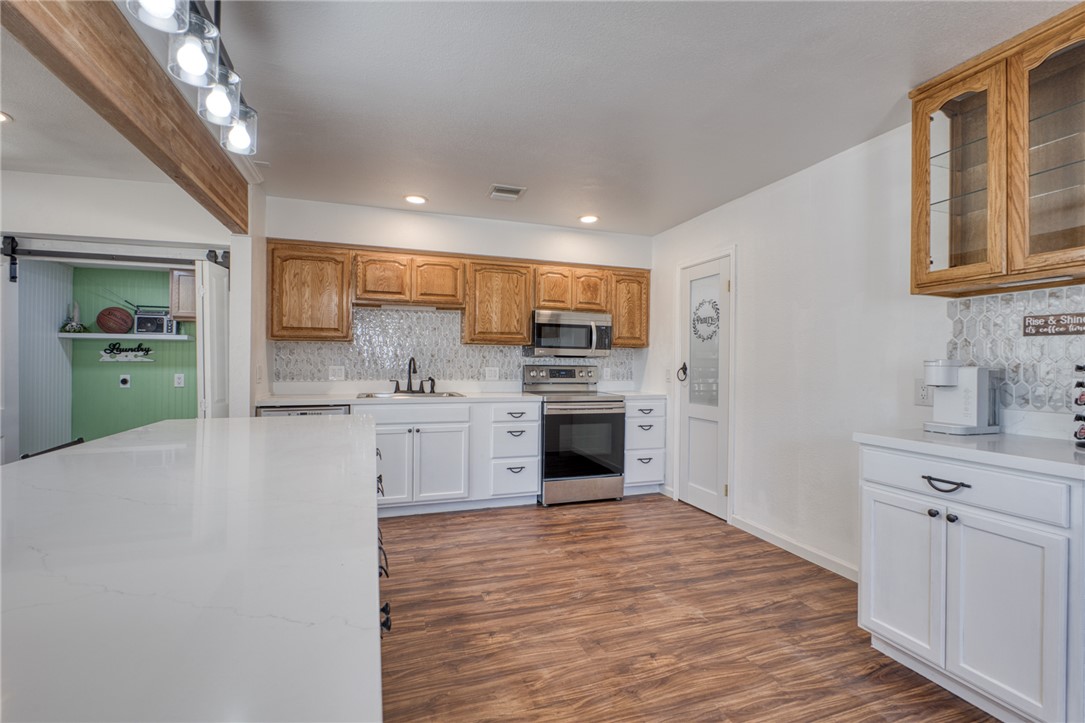 2053 Regents Road Mohave Valley, AZ 86440 - Photo 11 of 65 The kitchen features wood plank flooring, a white countertop, and white cabinetry