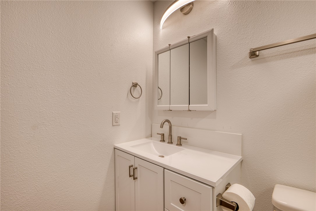 2053 Regents Road Mohave Valley, AZ 86440 - Photo 22 of 65 The bathroom features a vanity with a white countertop and sink, brushed nickel faucet, and a medicine cabinet with mirrored doors
