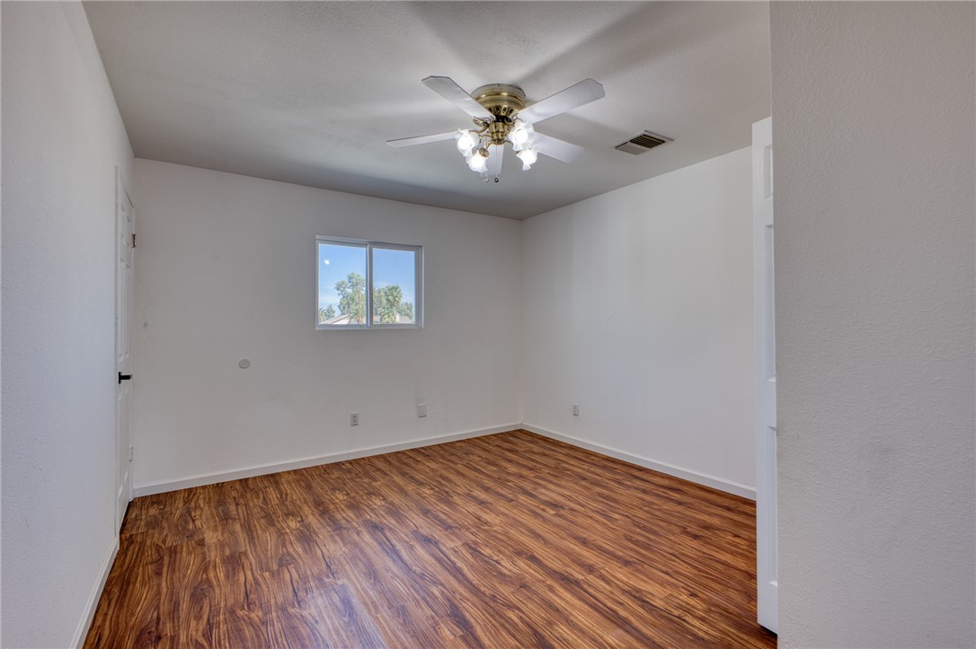 2053 Regents Road Mohave Valley, AZ 86440 - Photo 26 of 65 An inviting room featuring wood-look flooring, a window offering exterior views, and a ceiling fan