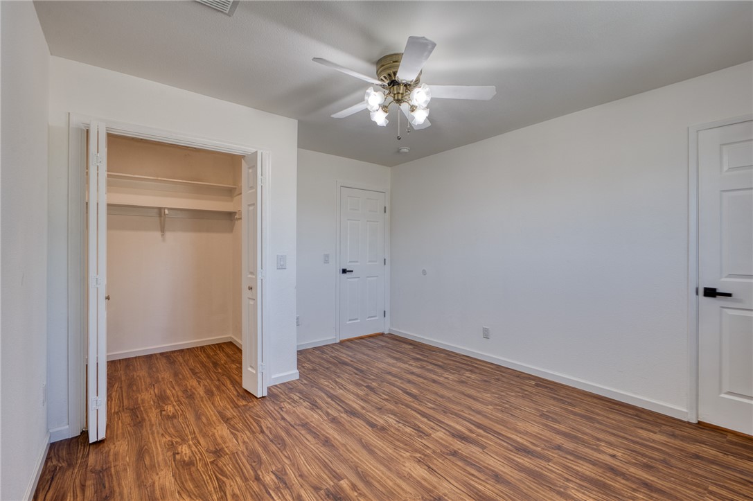 2053 Regents Road Mohave Valley, AZ 86440 - Photo 27 of 65 This room features wood-look flooring, a closet with bifold doors, a ceiling fan with integrated lighting, and white interior doors