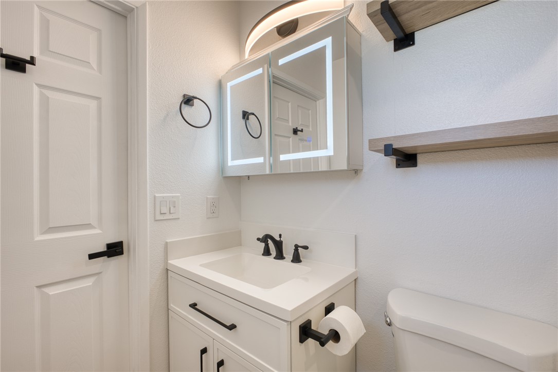 2053 Regents Road Mohave Valley, AZ 86440 - Photo 32 of 65 Bathroom with a modern vanity, illuminated mirrored medicine cabinet, and floating shelves