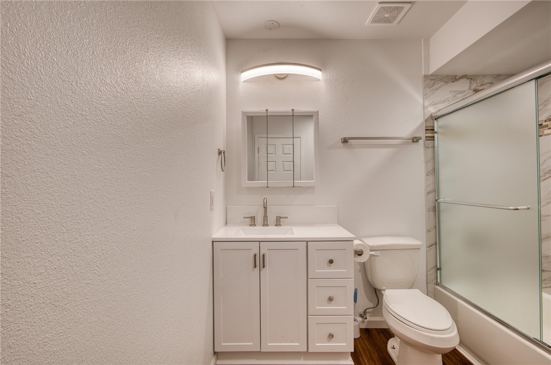 2053 Regents Road Mohave Valley, AZ 86440 - Photo 35 of 65 Bathroom featuring a white vanity with a rectangular sink, a medicine cabinet, and a shower with frosted glass doors