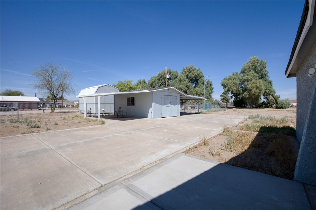2053 Regents Road Mohave Valley, AZ 86440 - Photo 37 of 65 The property features a concrete driveway and an outbuilding with an attached carport