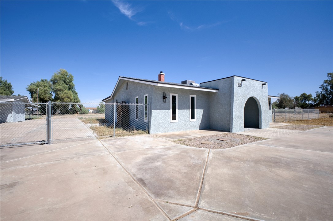 2053 Regents Road Mohave Valley, AZ 86440 - Photo 51 of 65 The property features a concrete driveway and an arched entryway, with stucco exterior walls and a fenced perimeter