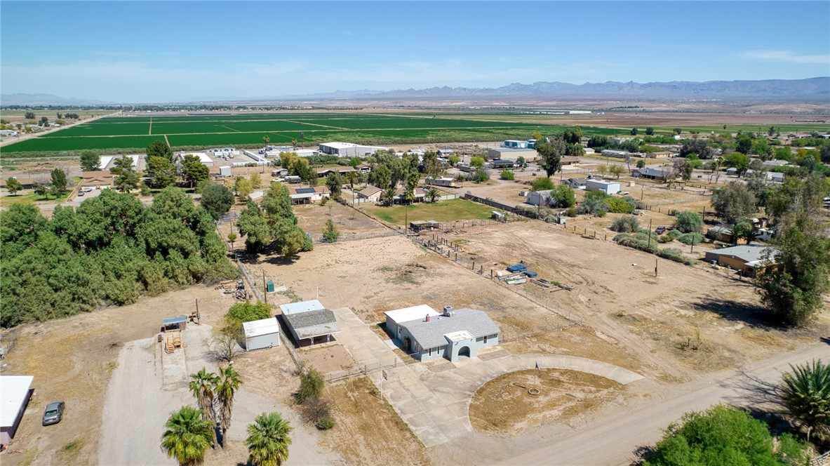 2053 Regents Road Mohave Valley, AZ 86440 - Photo 56 of 65 Aerial view of the property and its surrounding area, featuring a rural landscape with distant mountains, agricultural fields, and other residential structures
