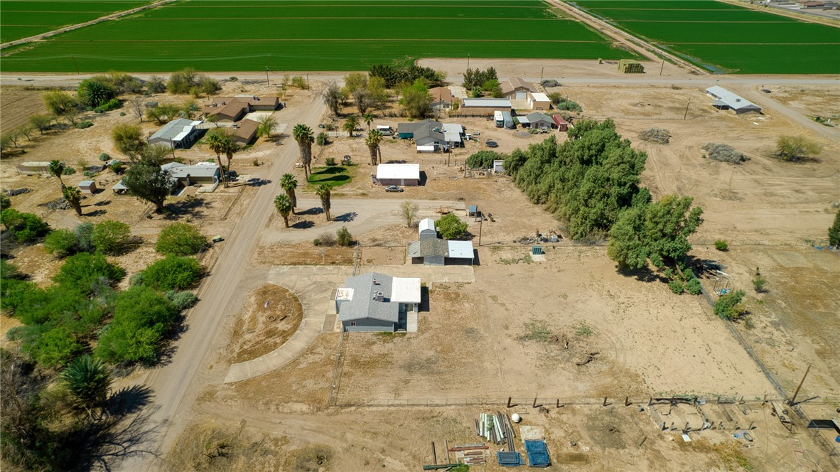 2053 Regents Road Mohave Valley, AZ 86440 - Photo 60 of 65 This aerial view showcases a property with a paved circular driveway, a single-story building with a gray roof, and surrounding arid landscaping