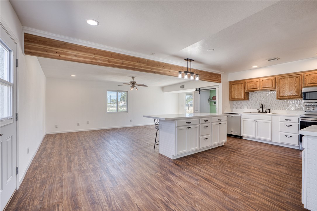 2053 Regents Road Mohave Valley, AZ 86440 - Photo 7 of 65 Expansive kitchen and living area featuring wood-look flooring, a kitchen island with seating, a ceiling fan, and recessed lighting